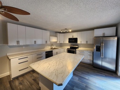 Wake up every morning to a serene golf course and water views in on Pine Island Ridge Country Club in Florida - for sale on GolfHomes.com, golf home, golf lot