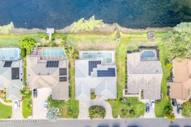 Drive up the pavered circular driveway framed by lush on Baytree National Golf Links in Florida - for sale on GolfHomes.com, golf home, golf lot