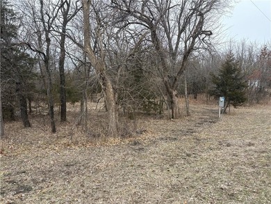 Tucked among mature trees on a rare double corner lot on Linn Valley Lakes - Deer Trace Golf Course in Kansas - for sale on GolfHomes.com, golf home, golf lot