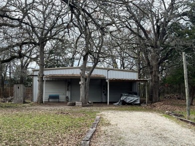 Sitting off the road nestled in trees is a Large on Tawakoni Golf Course in Texas - for sale on GolfHomes.com, golf home, golf lot