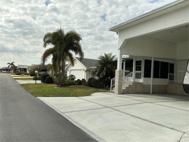 This house sits on a lot & 1/2 with an oversize two car garage on Lily Lake Golf and RV Resort in Florida - for sale on GolfHomes.com, golf home, golf lot