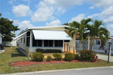 Move-in ready residence framed by swaying palms  adorned with on Six Lakes Country Club in Florida - for sale on GolfHomes.com, golf home, golf lot