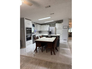 Indulge in expansive living within this magnificent double-wide on Hamptons Golf Club in Florida - for sale on GolfHomes.com, golf home, golf lot