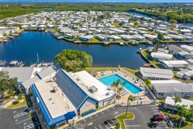 This 2 bedroom 1 1/2 bath home has a screened in porch and on Mangrove Bay Golf Course in Florida - for sale on GolfHomes.com, golf home, golf lot
