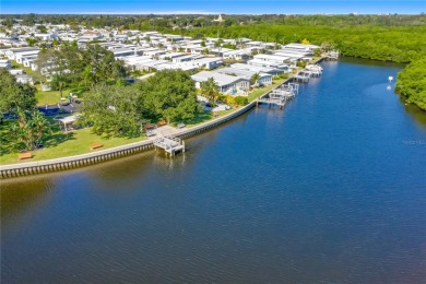 This 2 bedroom 1 1/2 bath home has a screened in porch and on Mangrove Bay Golf Course in Florida - for sale on GolfHomes.com, golf home, golf lot