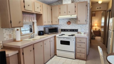 TWO BED, ONE BATH HOME IN ACTIVE 55+ COMMUNITY! This furnished on River Run Golf Links in Florida - for sale on GolfHomes.com, golf home, golf lot