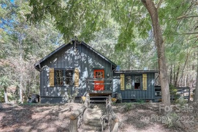 Great location for this 1930's cabin in the woods, nestled in 1 on Rumbling Bald Resort on Lake Lure in North Carolina - for sale on GolfHomes.com, golf home, golf lot