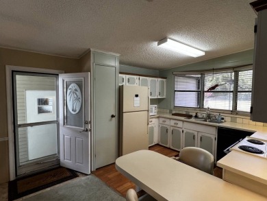 This charming 2-bedroom, 2-bathroom home offers stunning views on Lake Henry Golf Club in Florida - for sale on GolfHomes.com, golf home, golf lot