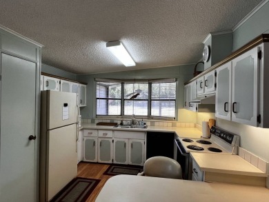 This charming 2-bedroom, 2-bathroom home offers stunning views on Lake Henry Golf Club in Florida - for sale on GolfHomes.com, golf home, golf lot