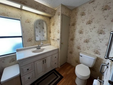 This charming 2-bedroom, 2-bathroom home offers stunning views on Lake Henry Golf Club in Florida - for sale on GolfHomes.com, golf home, golf lot