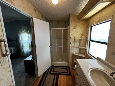 This charming 2-bedroom, 2-bathroom home offers stunning views on Lake Henry Golf Club in Florida - for sale on GolfHomes.com, golf home, golf lot