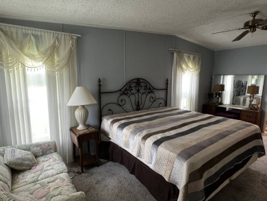 This charming 2-bedroom, 2-bathroom home offers stunning views on Lake Henry Golf Club in Florida - for sale on GolfHomes.com, golf home, golf lot
