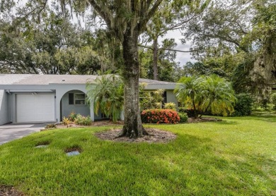 Tucked beneath the shade of moss-draped oaks and overlooking on Tarpon Woods Golf Club in Florida - for sale on GolfHomes.com, golf home, golf lot
