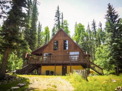 Discover this updated cabin retreat steps from golfing, fishing on El Valle Escondido Golf Course in New Mexico - for sale on GolfHomes.com, golf home, golf lot