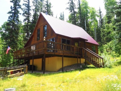 Discover this updated cabin retreat steps from golfing, fishing on El Valle Escondido Golf Course in New Mexico - for sale on GolfHomes.com, golf home, golf lot