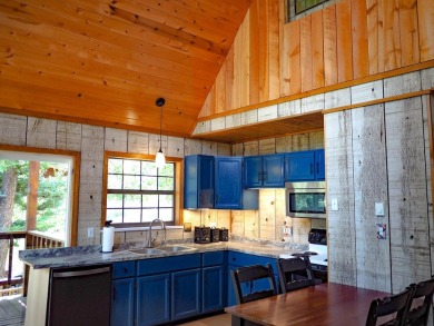 Discover this updated cabin retreat steps from golfing, fishing on El Valle Escondido Golf Course in New Mexico - for sale on GolfHomes.com, golf home, golf lot