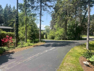 Discover unparalleled executive living perfectly situated on the on Traverse City Golf and Country Club in Michigan - for sale on GolfHomes.com, golf home, golf lot