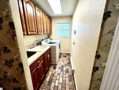 Discover unparalleled executive living perfectly situated on the on Traverse City Golf and Country Club in Michigan - for sale on GolfHomes.com, golf home, golf lot