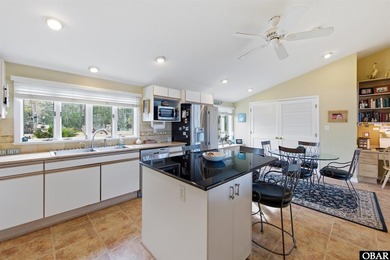 This single-story creek-side home aligns with the surrounding on Duck Woods Country Club in North Carolina - for sale on GolfHomes.com, golf home, golf lot