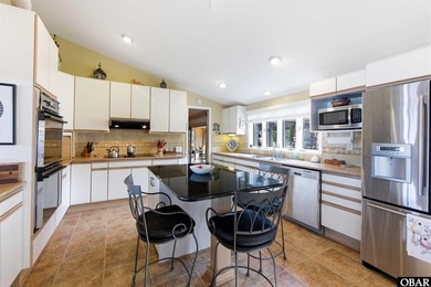 This single-story creek-side home aligns with the surrounding on Duck Woods Country Club in North Carolina - for sale on GolfHomes.com, golf home, golf lot