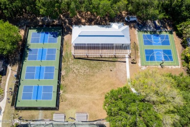 Nestled beneath a canopy of mature oak trees in the gated on Queens Harbour Yacht and Country Club in Florida - for sale on GolfHomes.com, golf home, golf lot