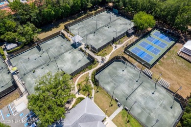 Nestled beneath a canopy of mature oak trees in the gated on Queens Harbour Yacht and Country Club in Florida - for sale on GolfHomes.com, golf home, golf lot
