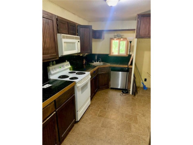 This 2-bedroom, 1-bath home has two lots totalling .75-acre lot on Bella Vista - Metfield Golf Complex and Country Club in Arkansas - for sale on GolfHomes.com, golf home, golf lot