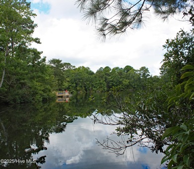 A beautiful nicely wooded home site with a generous pond view in on Rivers Edge Golf Club in North Carolina - for sale on GolfHomes.com, golf home, golf lot