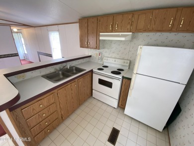 This 2 bedrooms, 1 bath manufactured home sits on a corner lot on Chowan Golf and Country Club in North Carolina - for sale on GolfHomes.com, golf home, golf lot