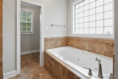 Nestled in a peaceful setting in Gates Four, this beautiful home on Gates Four Golf and Country Club in North Carolina - for sale on GolfHomes.com, golf home, golf lot