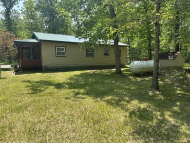 This well kept 2 bedroom is in a great location with paved road on Marquette Trails Country Club in Michigan - for sale on GolfHomes.com, golf home, golf lot