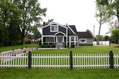 This cottage style bungalow surrounded by a white picket fence on Evergreen Hills Golf Course in Michigan - for sale on GolfHomes.com, golf home, golf lot