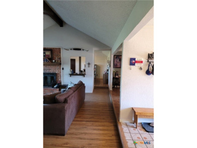 Enjoy a large main living room with a wood-burning fireplace on Hills of Cove Municipal Golf Course in Texas - for sale on GolfHomes.com, golf home, golf lot