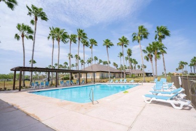Gorgeous palm tree line down the sparkling inground pool with on South Padre Island Golf Club in Texas - for sale on GolfHomes.com, golf home, golf lot