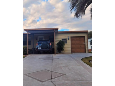 This manufactured home has a carport and a golf cart garage with on Orange Blossom Hills Golf and Country Club in Florida - for sale on GolfHomes.com, golf home, golf lot