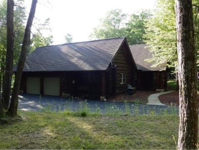 This stunning log home located on the 6th tee of Garland's on Garland Resort and Golf Club  in Michigan - for sale on GolfHomes.com, golf home, golf lot