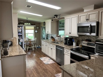 This home truly has it all! Attached RV port built to on Lily Lake Golf and RV Resort in Florida - for sale on GolfHomes.com, golf home, golf lot