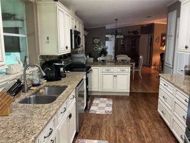 This home truly has it all! Attached RV port built to on Lily Lake Golf and RV Resort in Florida - for sale on GolfHomes.com, golf home, golf lot