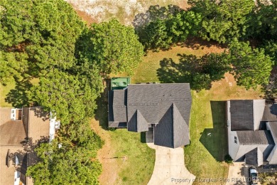 Step onto the covered porch to soak in the peaceful surroundings on Carolina Lakes Country Club in North Carolina - for sale on GolfHomes.com, golf home, golf lot