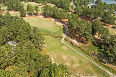 Step onto the covered porch to soak in the peaceful surroundings on Carolina Lakes Country Club in North Carolina - for sale on GolfHomes.com, golf home, golf lot