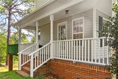 Step onto the covered porch to soak in the peaceful surroundings on Carolina Lakes Country Club in North Carolina - for sale on GolfHomes.com, golf home, golf lot