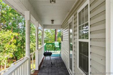 Step onto the covered porch to soak in the peaceful surroundings on Carolina Lakes Country Club in North Carolina - for sale on GolfHomes.com, golf home, golf lot