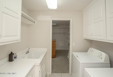 This expansive residence boasts 3 bedrooms, 3.5 bathrooms, and on Oyster Bay Golf Links in North Carolina - for sale on GolfHomes.com, golf home, golf lot