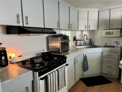 This 2 bedroom 1 1/2 bath home has a screened in porch and on Mangrove Bay Golf Course in Florida - for sale on GolfHomes.com, golf home, golf lot