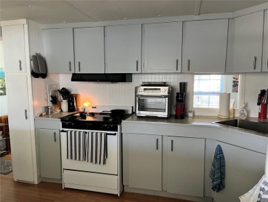This 2 bedroom 1 1/2 bath home has a screened in porch and on Mangrove Bay Golf Course in Florida - for sale on GolfHomes.com, golf home, golf lot