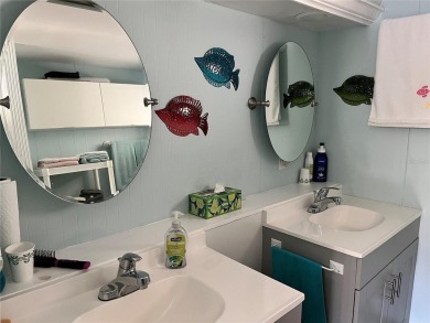 This 2 bedroom 1 1/2 bath home has a screened in porch and on Mangrove Bay Golf Course in Florida - for sale on GolfHomes.com, golf home, golf lot