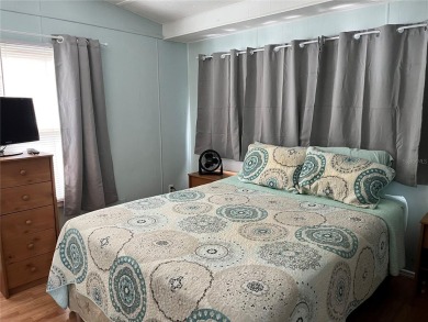 This 2 bedroom 1 1/2 bath home has a screened in porch and on Mangrove Bay Golf Course in Florida - for sale on GolfHomes.com, golf home, golf lot