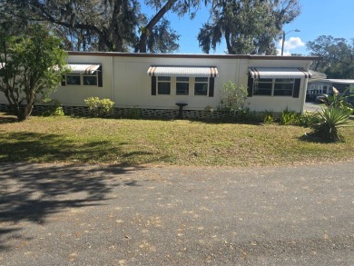 TWO DRIVEWAYS PROVIDE ADDITIONAL PARKING - NICE CORNER LOT - on Grasslands Golf and Country Club in Florida - for sale on GolfHomes.com, golf home, golf lot