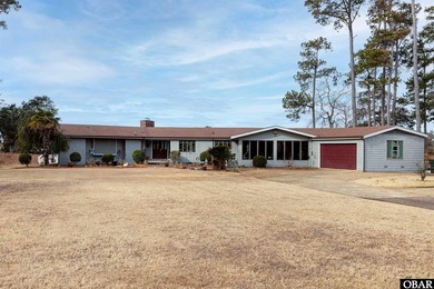 This single-story creek-side home aligns with the surrounding on Duck Woods Country Club in North Carolina - for sale on GolfHomes.com, golf home, golf lot