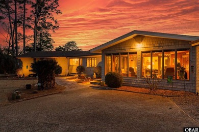 This single-story creek-side home aligns with the surrounding on Duck Woods Country Club in North Carolina - for sale on GolfHomes.com, golf home, golf lot